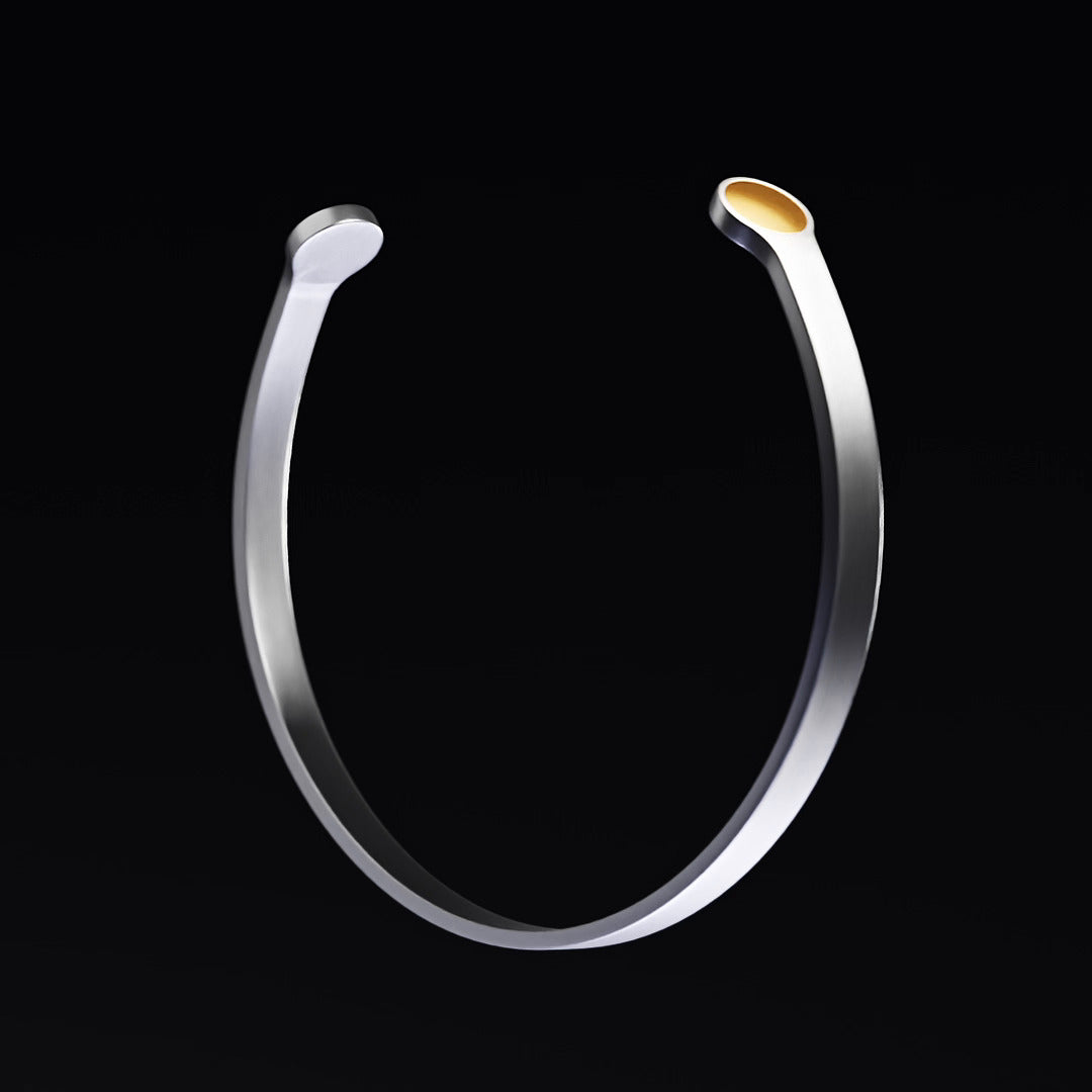 QiBracelet®, three-quarter view: open cuff with a gold chip